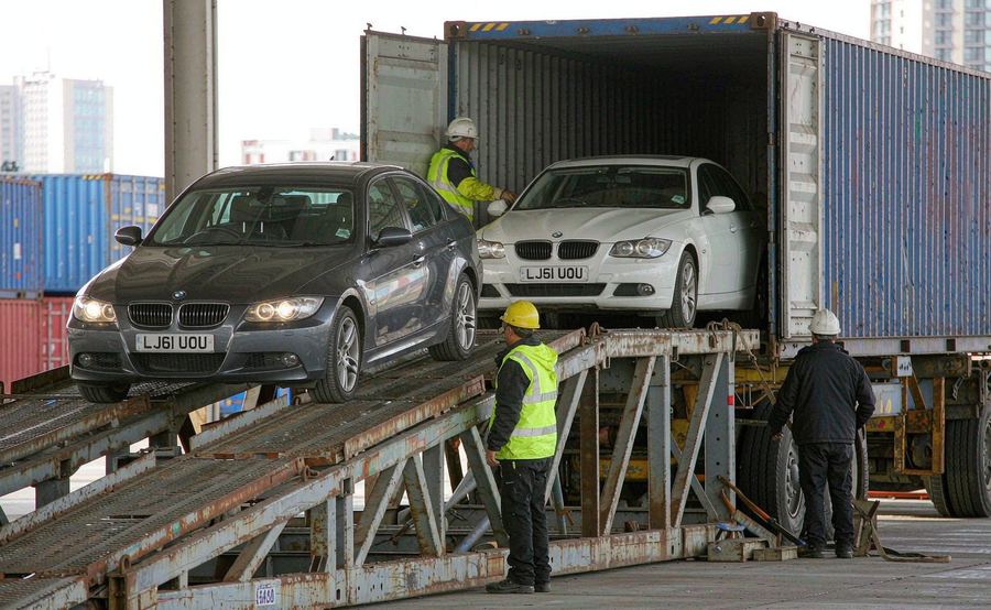 Cars being loaded into a shipping container at the export facility